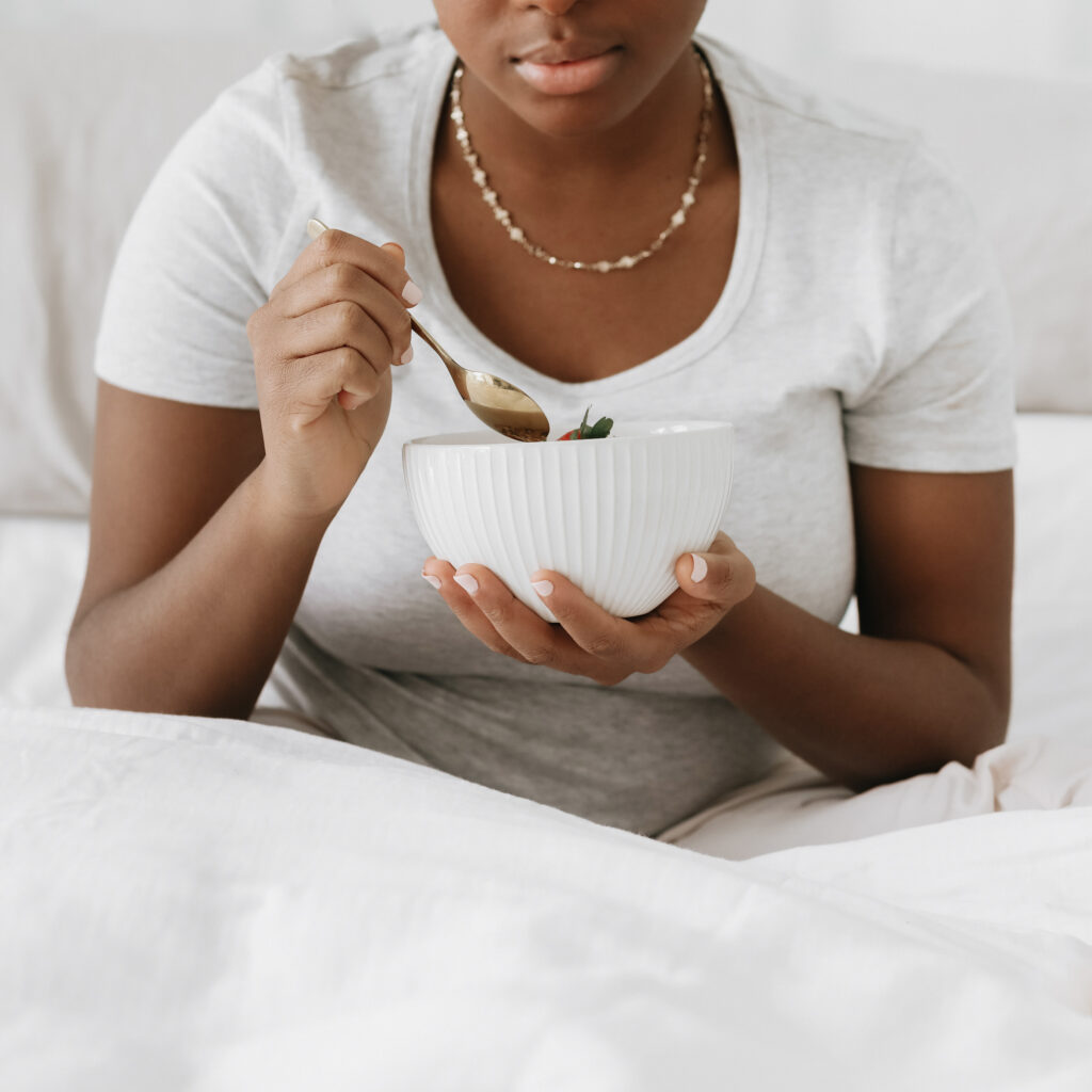 woman eating from white bowl