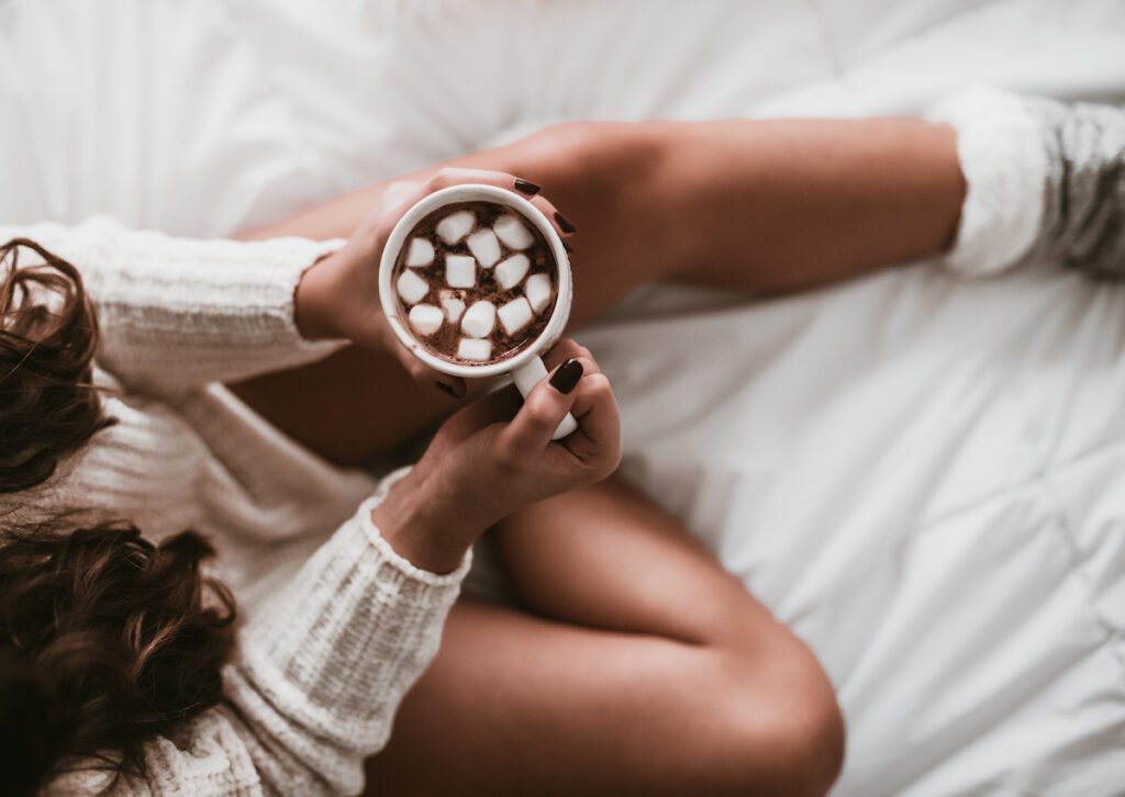 girl with dark hair sipping hot chocolate